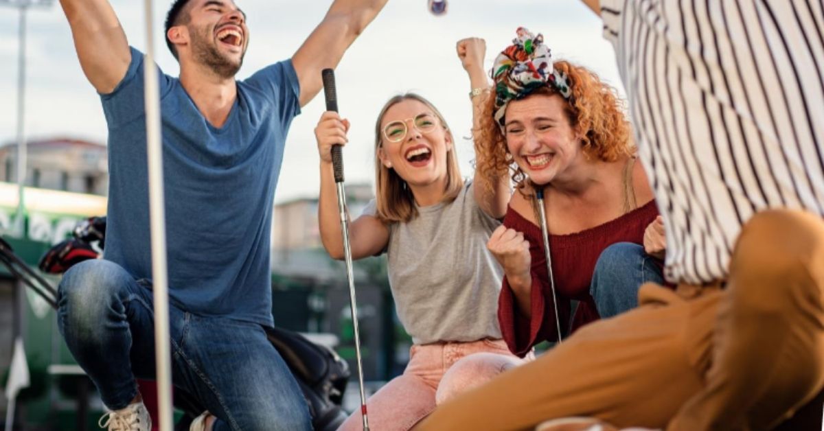 Eine Gruppe von Menschen feiert gerade ihren Erfolg beim Minigolf spielen.